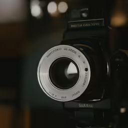 the front of a camera with an lens mounted to the side