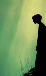 a man stands looking off into the distance while holding his hand