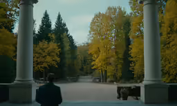 a person is standing in front of some columns