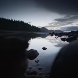 the sun is setting over a calm lake