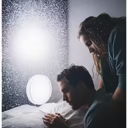 a man sitting in bed under the light from his phone