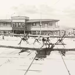 several small planes parked in front of a row of houses