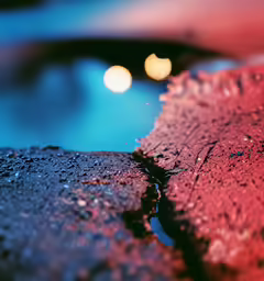 an artistic shot of a blue water and orange lights