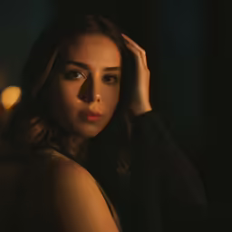 a beautiful woman wearing a black dress with a dark background