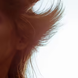 a woman in the sun is blowing her hair