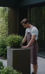 a man putting plants in a black planter