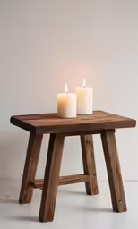 two candles are on a wooden table