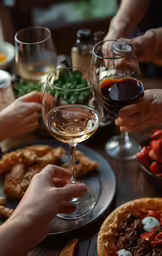 four people toasting their wine glasses at a dinner table
