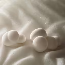 three hard boiled eggs lay on a white sheet