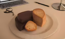 some slices of cake on a plate with a computer on a table
