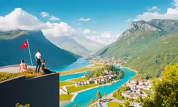 two people watch a beautiful valley and river on the edge