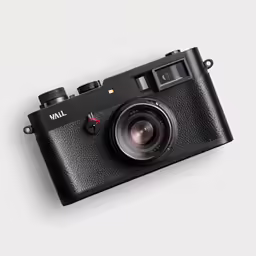 a black and white camera is shown with the lens facing upward
