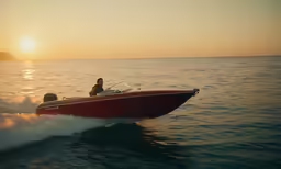 a small boat rides along the water as the sun sets
