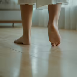 there is a person standing on a hard wood floor