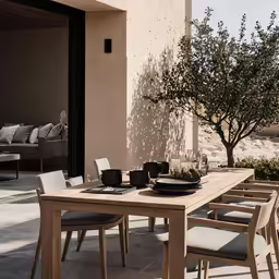 a table outside on the outside with a bowl of fruit and plates on top