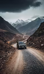 a vehicle is driving down the road through mountains