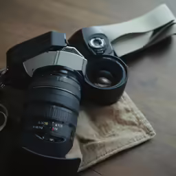 a couple of cameras sitting on top of a wooden table