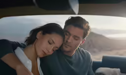 a man and woman sitting in the back seat of a car