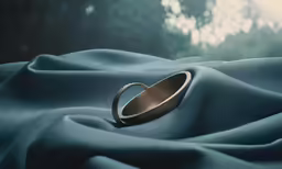 the gold ring has been placed on the blue fabric