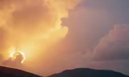sun setting behind clouds in the sky