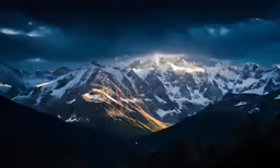 a view of the snowy mountains with sun peaking in