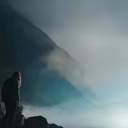 two people are looking at the sky with a mountain in the distance