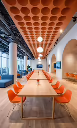 this is a large meeting room with orange chairs
