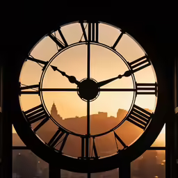 a clock with a city skyline and buildings in the background