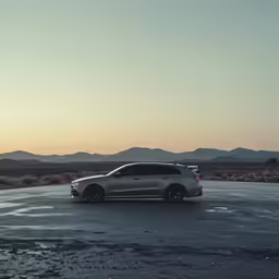 a silver car is parked on a wet road