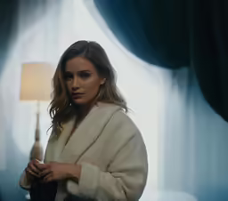 a woman in white sweater with lights on a desk