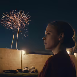 a beautiful woman standing in front of fireworks