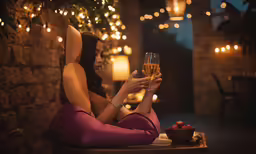 a woman sits at an outdoor bar with a wine glass