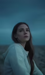 the young woman is staring out at the distant horizon