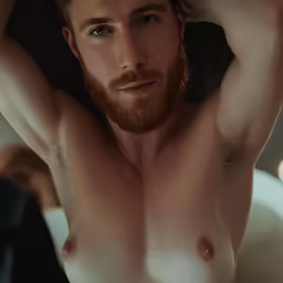 a man with a goatee and no shirt holds his head over his shoulder