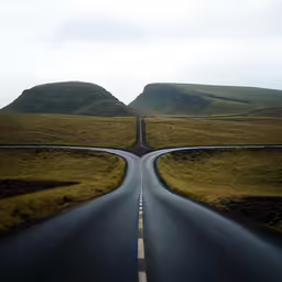 two roads running parallel in front of an open field