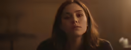 a woman looks concerned while looking in her room