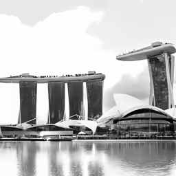 architectural buildings sit next to the water on a sunny day
