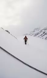 the man hiking up a snowy hill alone
