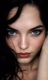a woman with dark makeup and large blue eyes