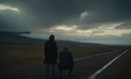 a couple is sitting on the side of a road