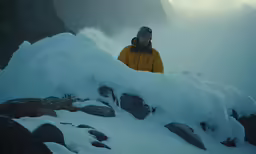a man stands on top of the snowy mountain
