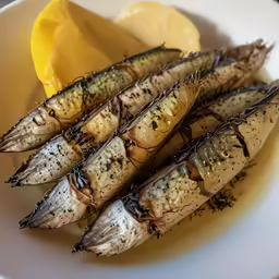 several grilled dead fish are on the plate