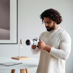 a man holding a camera near a table