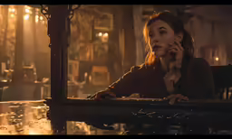 the woman is talking on her cellphone in the pub