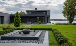 there is a house with a beautiful lawn and some stones