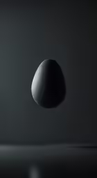 a black rock with white paint sitting on a black surface