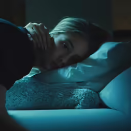 a woman laying down next to a man with a hat on