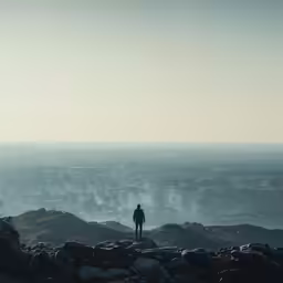 the man is standing on top of the mountain