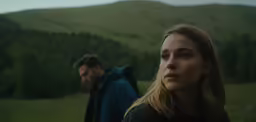 a woman standing next to a man with a backpack