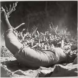 a woman lying on top of a rock with her legs crossed